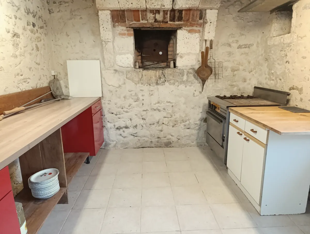 La cuisine d'été et son four à pain dans le mur de pierre