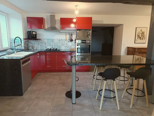 La cuisine rouge et son grand îlot noir