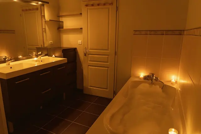 La salle d'eau éclairée aux bougies, sa baignoire et sa double vasque
